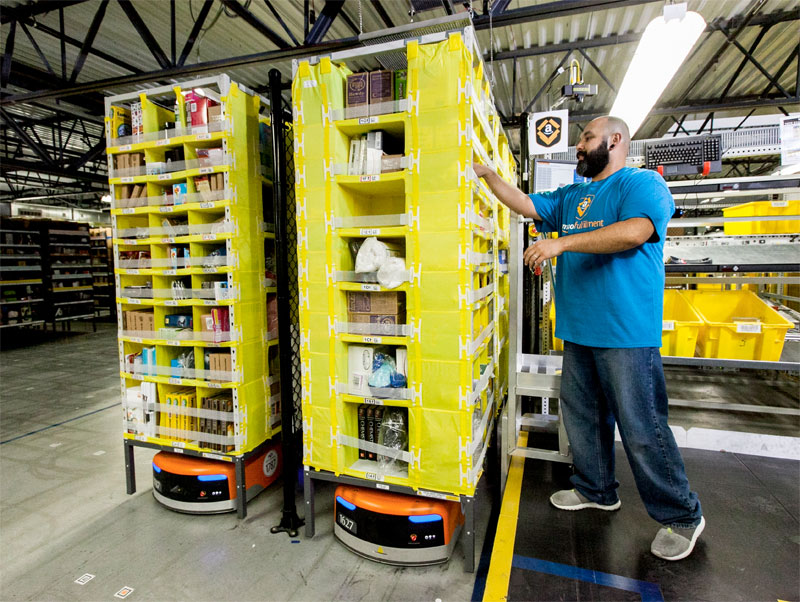 Amazon's squat orange robots slide under and transport shelves packed with product. PHOTO: Amazon.com Inc.