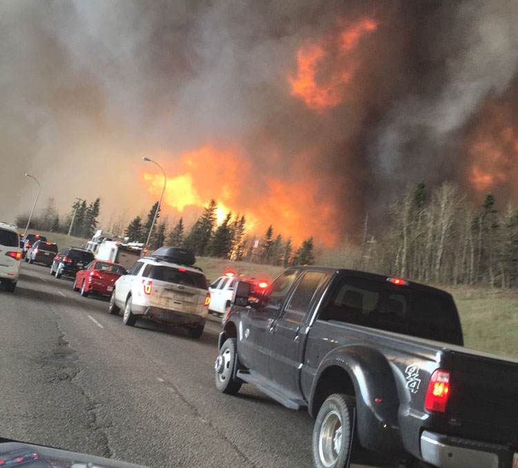 People fleeing flames from the Fort McMurray forest fire in the area of Highway 63 South. PHOTO: DarrenRD. CC-BY-SA-4.0